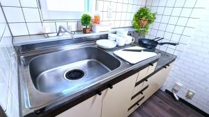 a stainless steel sink in a small kitchen at KIYAZA Home Sapporo in Sapporo +34 photos