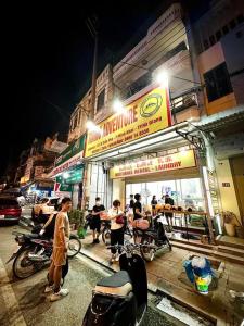 a group of people standing outside a restaurant at night at Hà Giang Tiamo Adventure in Ha Giang
