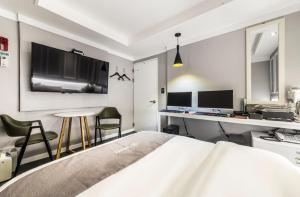 ein Schlafzimmer mit einem Bett und einem Schreibtisch mit zwei Monitoren in der Unterkunft SL Hotel in Incheon