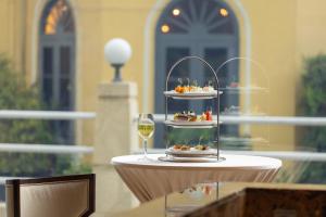 a table with a plate of food and a glass of wine at Eastin Grand Hotel Sathorn in Bangkok