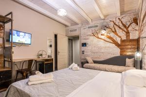 Santa Maria di LicodiaにあるCorten Hotelのベッドルーム(ベッド1台、ソファ、テレビ付)