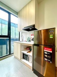 La cuisine est équipée d'un réfrigérateur en acier inoxydable et d'un four micro-ondes. dans l'établissement May Apartment My Dinh Hanoi, à Hanoï