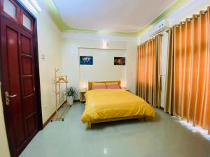 um quarto com uma cama com uma colcha amarela em Su Homestay em Cao Bang