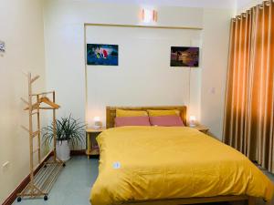 um quarto com uma cama com um cobertor amarelo em Su Homestay em Cao Bang