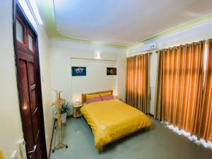 een slaapkamer met een geel bed in een kamer bij Su Homestay in Cao Bằng