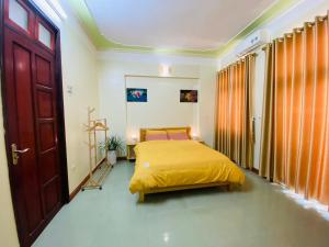 ein Schlafzimmer mit einem Bett mit einer gelben Decke in der Unterkunft Su Homestay in Cao Bằng