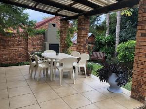 a white table and chairs on a patio at Dew Drop Inn in Nelspruit