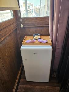 a small refrigerator in a room with a window at Lotus Guest House Malta in Il-Gżira