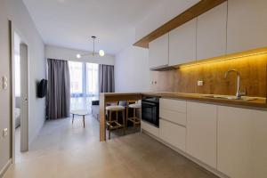 a kitchen with white cabinets and a dining room at SKG Central Gateaway in Thessaloniki