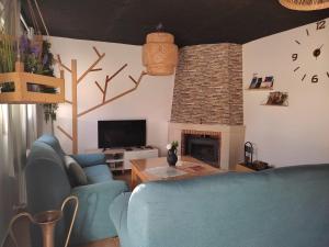 a living room with blue chairs and a fireplace at "La Villa de Iker" con Piscina, Barbacoa, Aire Acondionado a 5 mint de "Puy du Fou" in Argés