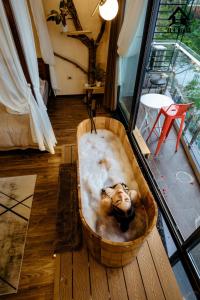una vasca da bagno con una donna in una stanza di Kang's Home Vũ Miên a Hanoi