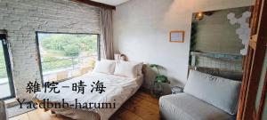 een slaapkamer met een bed, een raam en een stoel bij Yardbnb 2F in Jiufen
