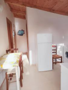 una cucina bianca con tavolo e frigorifero di 2 bedrooms apartement at Pisciotta 200 m away from the beach with furnished terrace a Pisciotta