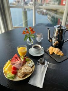 a black table with a plate of food and a cup of coffee at Villa Bryggekanten - by Classic Norway Hotels in Henningsvær