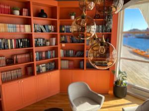 ein orangefarbenes Zimmer mit einem Bücherregal mit Büchern in der Unterkunft Villa Bryggekanten - by Classic Norway Hotels in Henningsvær