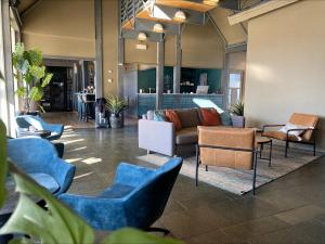 a lobby with blue chairs and a couch at Villa Bryggekanten - by Classic Norway Hotels in Henningsvær