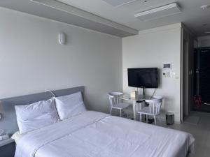 - une chambre avec un lit, une télévision et une table dans l'établissement Gurujam, à Daegu