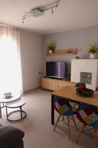 apartament dúplex "Alsina" في تريمب: غرفة معيشة مع طاولة وتلفزيون
