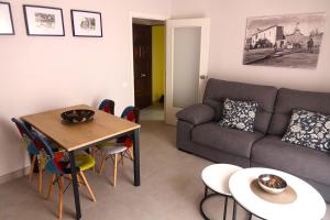 apartament dúplex "Alsina" في تريمب: غرفة معيشة مع أريكة وطاولة وكراسي