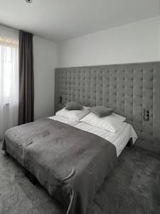 a bedroom with a large bed with a large headboard at Rosa Park in Rowy