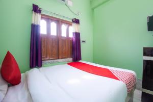 łóżko w pokoju z oknem w obiekcie OYO Hotel Taj International w mieście Baharampur