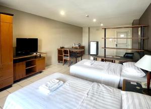 Habitación de hotel con 2 camas y TV de pantalla plana. en BU Place Hotel en Bangkok