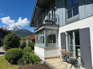 a building with a balcony and a table on a patio at Ferienwohnung Marianne Bergpanorama Eröffnung Juni 24 für Paare 60qm in Berchtesgaden