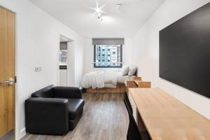 sala de estar con silla negra y cama en Modern Studios and Private Bedrooms with Shared Kitchen at Chapter Islington in London en Londres