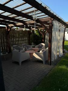 a wooden pergola with chairs and tables under it at Hütte54 in Goslar
