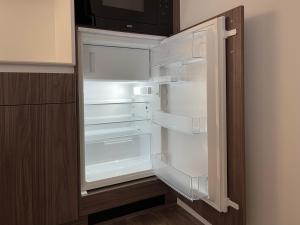 um frigorífico vazio com a porta aberta numa cozinha em Rosa Park em Rowy