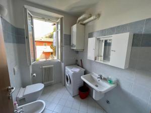 baño con lavabo y aseo y ventana en Appartamento Ai Crotti, en Dervio
