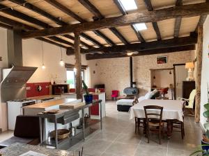 cocina y sala de estar con mesa y sillas en Périgourdine avec spa et vue en Pomport