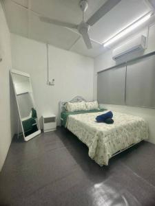 a bedroom with a bed and a mirror in it at Homestay Rumah Puteh Melaka in Kampong Bukit Katil