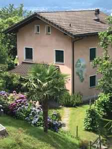 une maison avec un palmier dans la cour dans l'établissement La Preferita, à Magadino