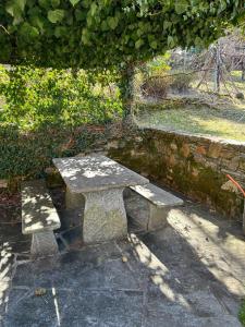 un banc en pierre assis à côté d'un mur en pierre dans l'établissement La Preferita, à Magadino