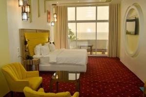 une chambre d'hôtel avec un lit, une chaise et une fenêtre dans l'établissement Hôtel du Phare, à Kribi