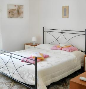 una camera da letto con letto nero e cuscini rosa di 3 bedrooms apartement at Trapani 100 m away from the beach with city view furnished balcony and wifi a Trapani