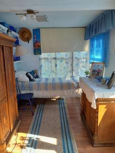 a bedroom with a bed and a table and a window at Pie Garozas in Lapmežciems