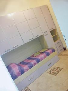 un letto in una camera con armadi bianchi di 3 bedrooms apartement at Trapani 100 m away from the beach with city view furnished balcony and wifi a Trapani