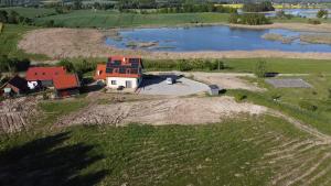 an aerial view of a house in a field next to a lake at Pęglity jezioro in Gietrzwałd