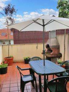 - une table et des chaises avec un parasol sur la terrasse dans l'établissement 3 bedrooms apartement with furnished terrace and wifi at Astorga, à Astorga