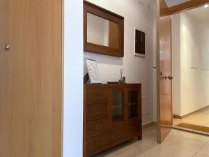 a room with a wooden dresser and a mirror at Apartment Marina in Vilanova i la Geltrú