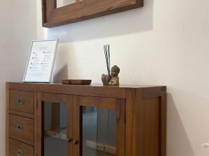 a wooden cabinet with a figurine on top of it at Apartment Marina in Vilanova i la Geltrú