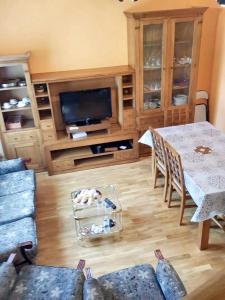 a living room with a table and a tv at 3 bedrooms apartement with furnished terrace and wifi at Astorga in Astorga