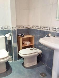 La salle de bains est pourvue de toilettes blanches et d'un lavabo. dans l'établissement 3 bedrooms apartement with furnished terrace and wifi at Astorga, à Astorga