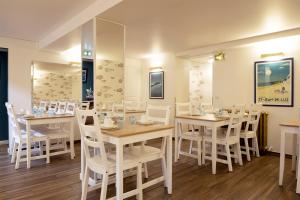 un comedor con mesas blancas y sillas blancas en Hotel Le Relais Saint-Jacques, en San Juan de Luz