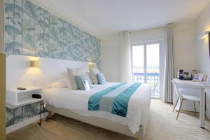 una camera da letto con un letto, una scrivania e una scrivania di Hotel Le Relais Saint-Jacques a Saint-Jean-de-Luz