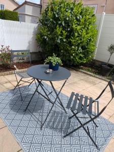 stół i dwa krzesła siedzące na dywanie w obiekcie Cosy Appart’ & spa - Appartement privatif - baignoire balnéothérapie 