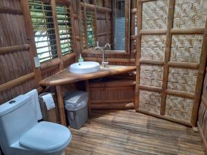 een badkamer met een toilet en een wastafel bij Kookoo's nest eco-lodge in Siaton