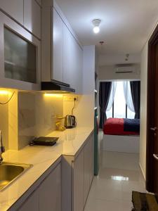 バタム・センターにあるPETITE MAISON at POLLUX HABIBIE BATAMのシンク付きのキッチンとベッド付きの部屋